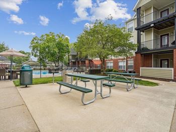 our picnic tables are in front of our apartments with a pool